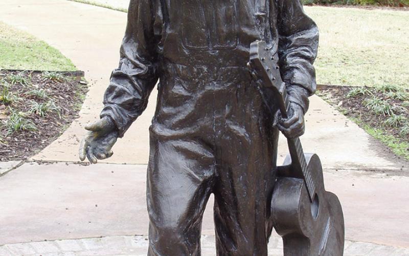 A statue of young Elvis Presley stands outside his humble birthplace in Tupelo, MS.