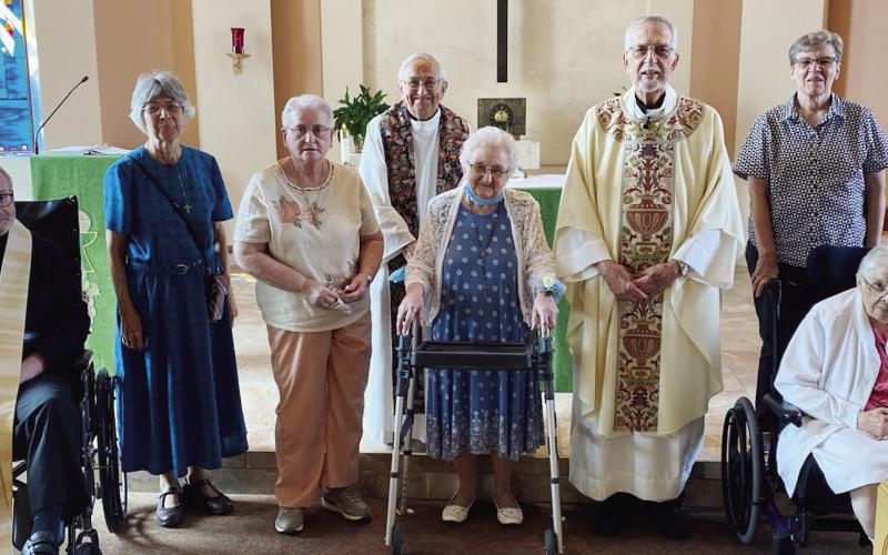 Jubilee Mass attendees and celebrants, including Father Dave Tscherne, gather around Sister Agnes Rose at The Gardens of St. Francis.