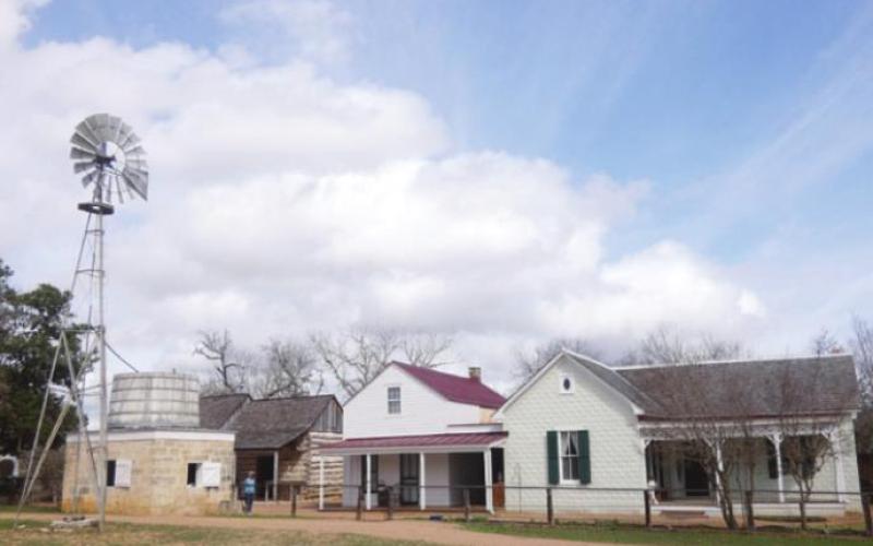 The “modern” farm included conveniences such as a windmill to pump water, a cistern to store it in during dry spells, and a cooling house for dairy products. Notice the Victorian-style white siding.