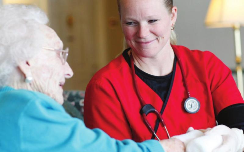 Stacey, an Elizabeth Scott staff member, cares for a resident (photo taken before the onset of the pandemic).