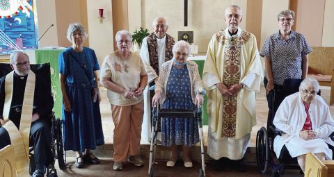 Jubilee Mass attendees and celebrants, including Father Dave Tscherne, gather around Sister Agnes Rose at The Gardens of St. Francis.
