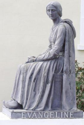 A statue of Evangeline stands behind St, Martin de Tours, the 1765 home church of the Cajuns.